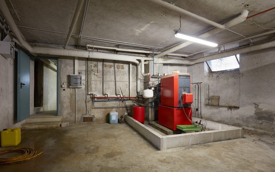Basement with red heating boiler in old house interior