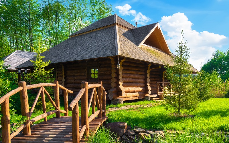 Wooden house in the forest in summer with wood foundation